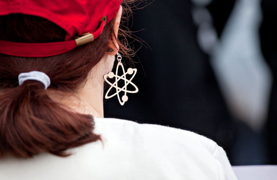 A woman wears an atheist symbol as an earring.