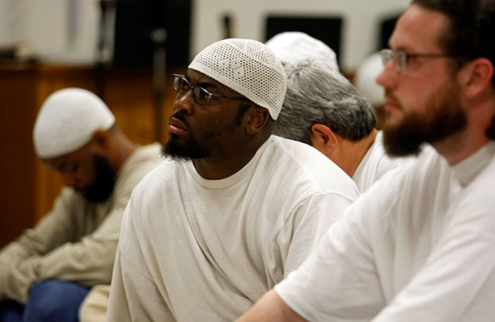 Orlando Wright, center, listens as the Imam speaks to the group of Muslim inmates, Friday, June 20, 2008 in Monroe, Wash.