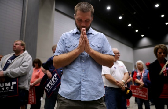 Supporters of Donald Trump pray at a campaign rally on November 5, 2016.